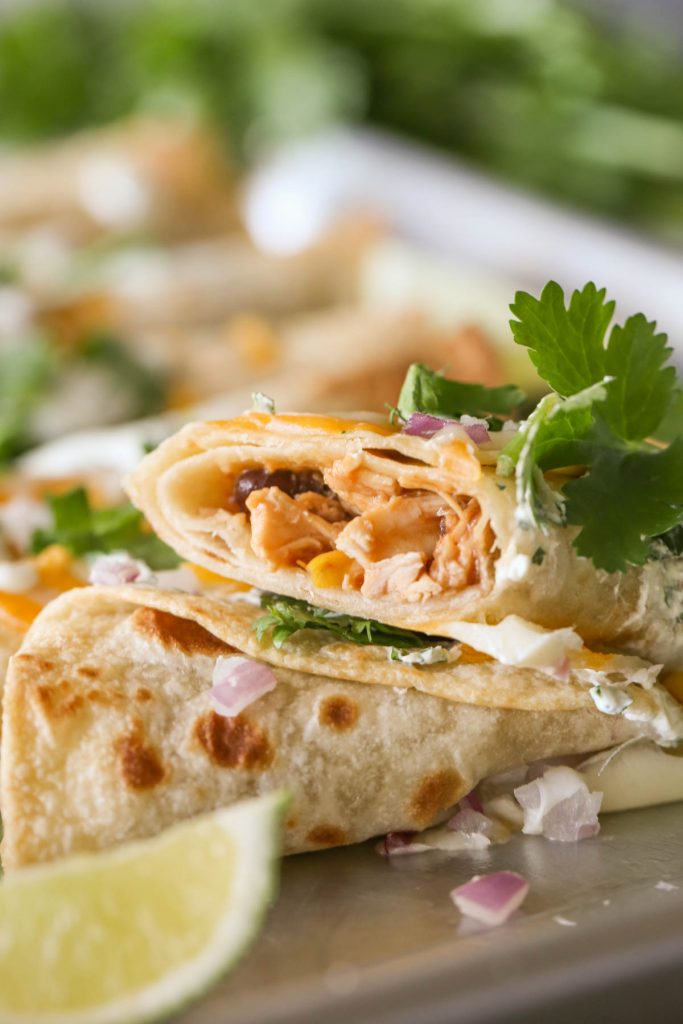 Close up shot of a BBQ Chicken Taquito cut in half, showing the inside of the taquito.