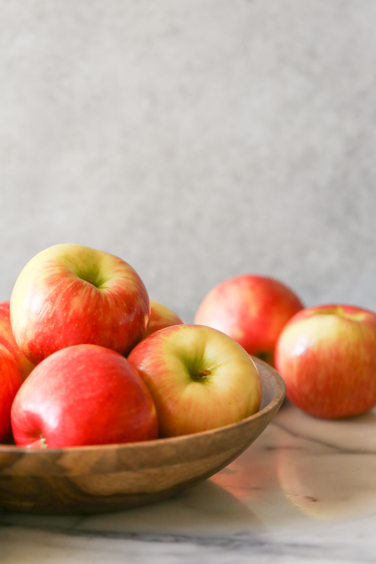 A wood bowl full of apples.  