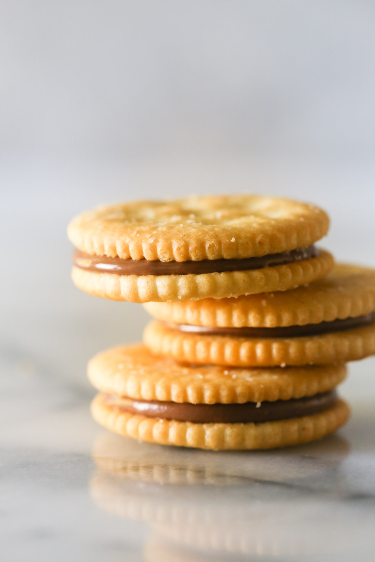 Three Ritz and Rolo sandwiches stacked on top of each other before they were dipped in chocolate.