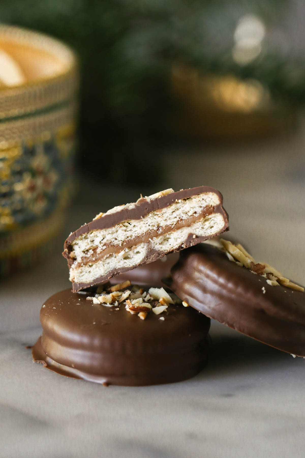 Close up shot of three Ritzy Rolo Cookies and a half of a Ritzy Rolo Cookie on stop showing the inside layers of the cookie.