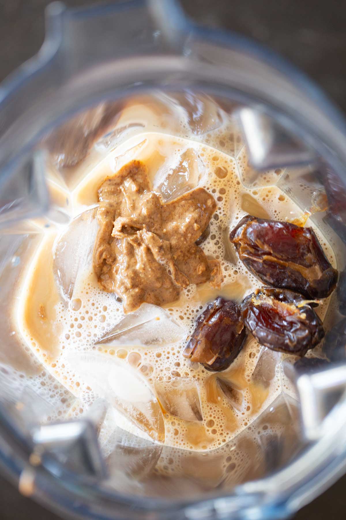 Overhead shot of all the ingredients for a Copycat Sprouts Date Coffee Smoothie in a blender. 