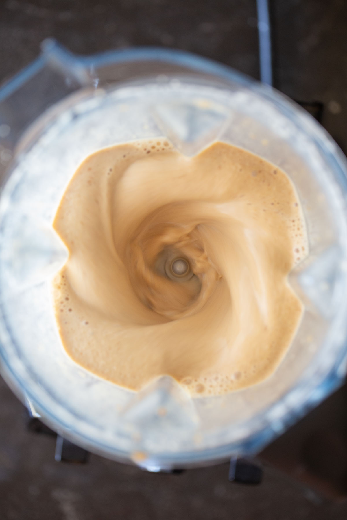 Overhead shot of the ingredients for a Copycat Sprouts Date Coffee Smoothie mixing in a blender. 